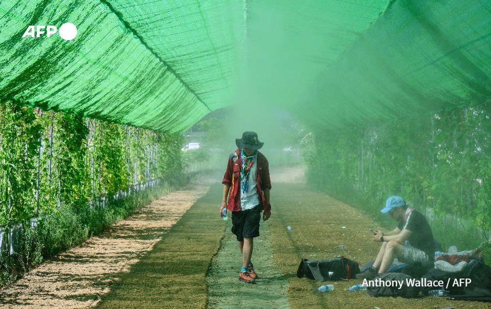 A scout cools himself under a spray of water mist